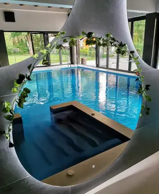 a large swimming pool with blue water in a building at Vila Pozitiv in Sisevac