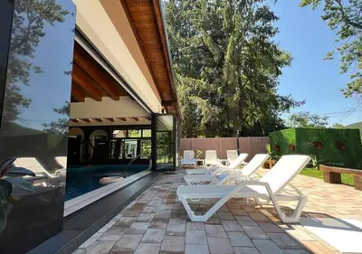a patio with white chairs and a swimming pool at Vila Pozitiv in Sisevac