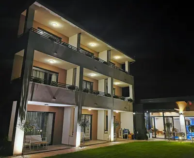 a large house at night with a lawn in front at Vila Pozitiv in Sisevac