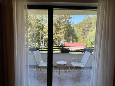 a view of a balcony with white chairs and a table at Vila Pozitiv in Sisevac