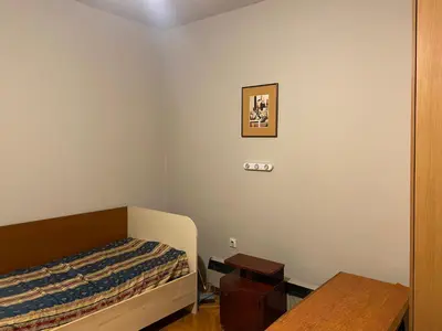a small bedroom with a bed and a table at Neda in Niš