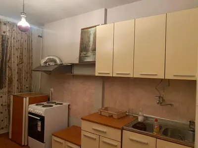 a kitchen with white cabinets and a sink and a stove at Neda in Niš