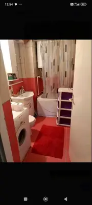 a bathroom with a white toilet and a red floor at Apartman Krstic in Jagodina