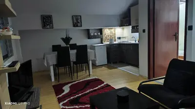 a living room with a kitchen and a table and chairs at JetNest in Niš
