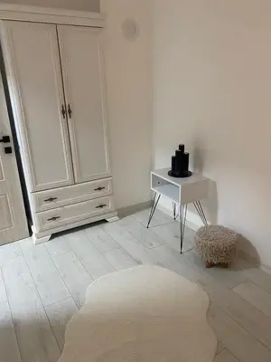 a white room with a table and a white cabinet at Day and night in Prokuplje