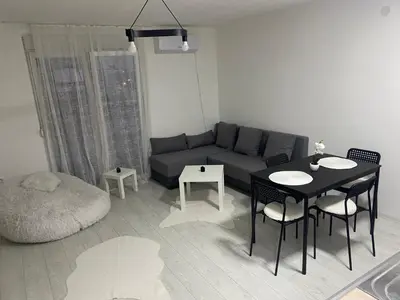 a living room with a couch and a table and chairs at Day and night in Prokuplje