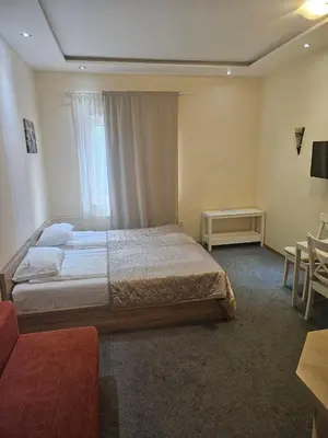 a hotel room with a bed and a table and chairs at APEX Konaci Koznik in Kopaonik