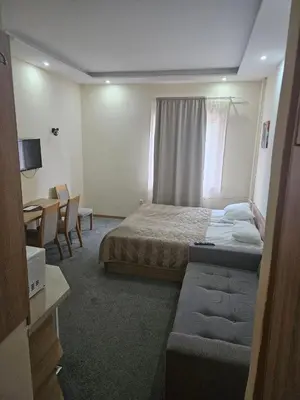 a hotel room with a bed and a couch at APEX Konaci Koznik in Kopaonik
