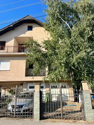 a building with a fence in front of a tree at Travel Rest in Bujanovac