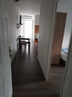 a hallway with a table and a room with a bedroom at Prenociste H2O in Paraćin