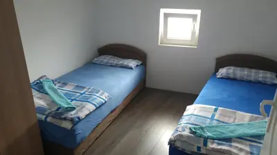 two beds in a small bedroom with a window at Prenociste H2O in Paraćin