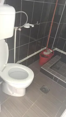 a bathroom with a white toilet and a broom at Prenociste H2O in Paraćin