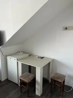 a white table with two stools in a room at Prenociste H2O in Paraćin