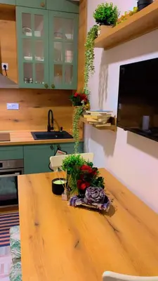 a kitchen with a wooden table with flowers on it at Clementine in Soko Banja