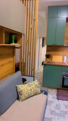 a living room with a couch and a kitchen at Clementine in Soko Banja