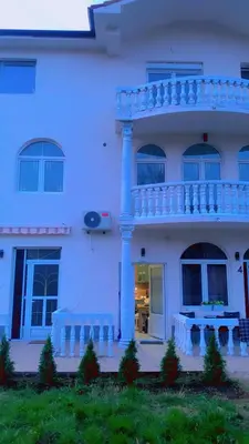 a white house with a balcony on the side of it at Clementine in Soko Banja