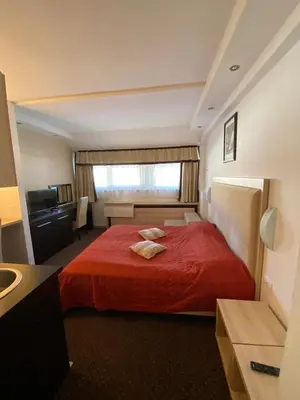 a hotel room with a red bed and a sink at Apartmani Vrh Konaci in Kopaonik