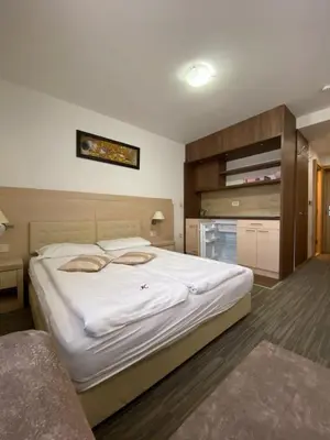 a bedroom with a large white bed in a room at Apartmani Vrh Konaci in Kopaonik