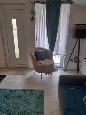 a living room with a chair and a window at Apartman Viktorija in Jošanička Banja