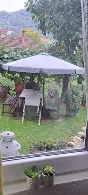 a view of a table and umbrella from a window at Apartman Viktorija in Jošanička Banja