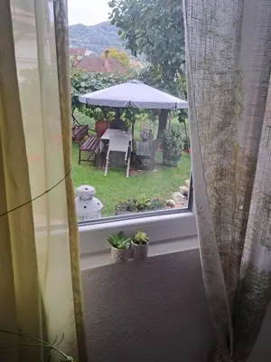 a window with a view of a patio with an umbrella at Apartman Viktorija in Jošanička Banja