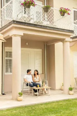 a man and woman sitting on a table on a patio at Vila Nada Sokobanja in Soko Banja