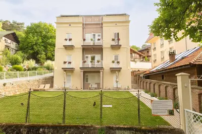 a house with a tennis court in front of a fence at Vila Nada Sokobanja in Soko Banja