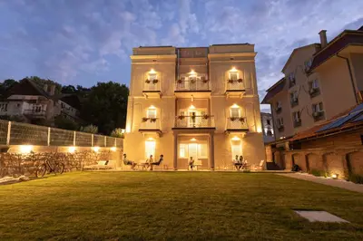 a large building with people sitting on a lawn at Vila Nada Sokobanja in Soko Banja