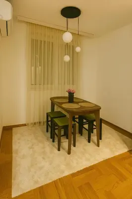 a dining room with a table and green chairs at Luxury Stay in Vrnjačka Banja C2 in Vrnjačka Banja