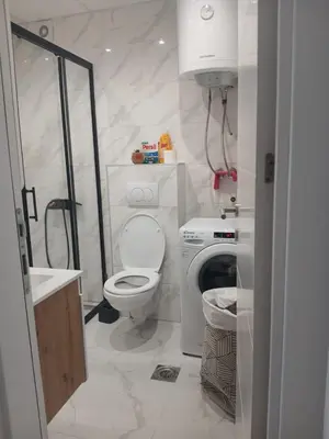 a white bathroom with a toilet and a sink at Aprtman SALE in Vrnjačka Banja