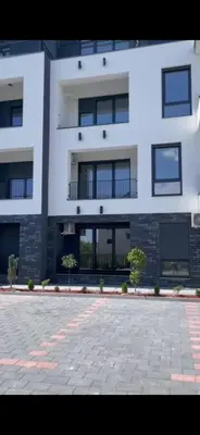 a large white building with windows and a courtyard at Aprtman SALE in Vrnjačka Banja