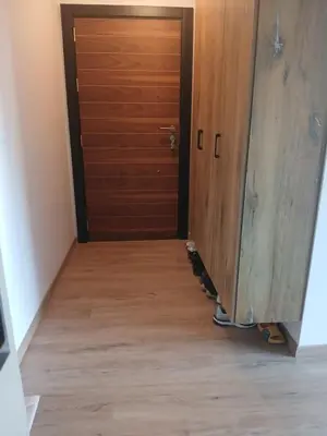 a hallway with a door and a wooden floor at Aprtman SALE in Vrnjačka Banja