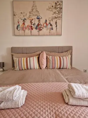 a bedroom with a bed with a picture on the wall at Apartman Iris in Pirot