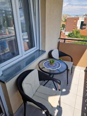 a balcony with a table and chairs and a window at Apartman Iris in Pirot