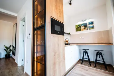 a kitchen with a refrigerator and two bar stools at Park Studio 19 in Vrnjačka Banja