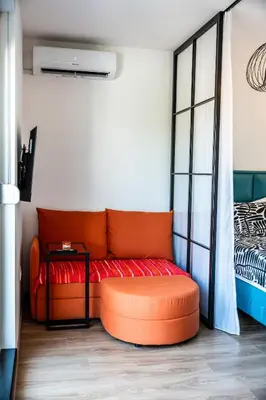 an orange couch in a room with a bed at Park Studio 19 in Vrnjačka Banja