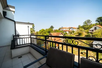 a balcony with two chairs and a view at Park Studio 19 in Vrnjačka Banja