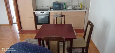 a kitchen with a wooden table with chairs and a microwave at DDS-Niš in Niš