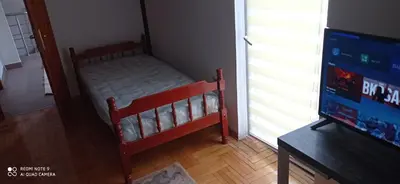 a small bed in a room with a tv at DDS-Niš in Niš