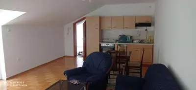 a living room with two chairs and a kitchen at DDS-Niš in Niš