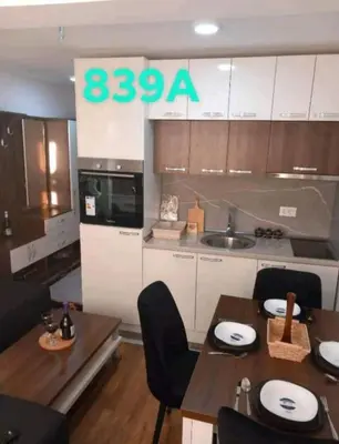 a kitchen with a table and chairs and a kitchen with a counter at Apartman President Kop in Kopaonik