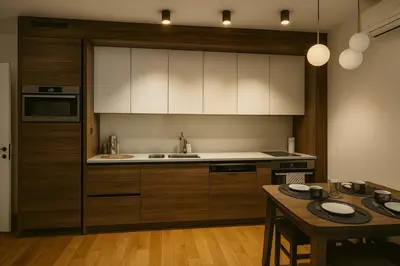 a kitchen with white cabinets and a wooden table at Luxury Stay in Vrnjačka Banja D3 in Vrnjačka Banja