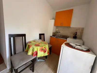 a small kitchen with a table and a refrigerator at Studio x2 in Jošanička Banja