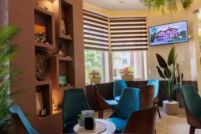a waiting room with blue chairs and a table at Garni Hotel Biser in Kruševac