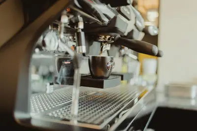 a coffee machine with a cup on a counter at Garni Hotel Biser in Kruševac