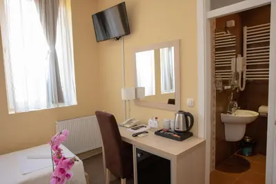a bathroom with a desk with a sink and a toilet at Garni Hotel Biser in Kruševac