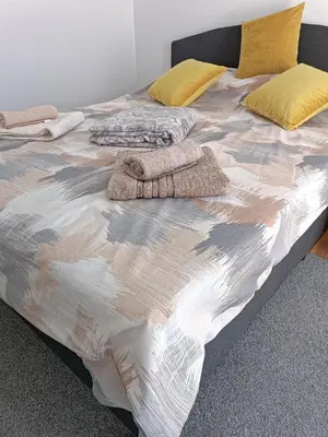 a bed with blankets and pillows on top of it at Lipa in Vrnjačka Banja