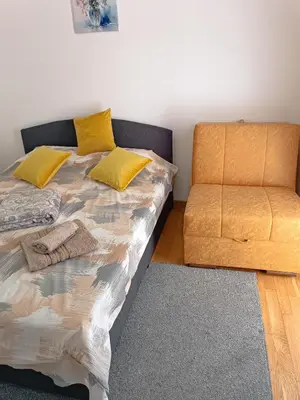 a bedroom with a bed and a couch at Lipa in Vrnjačka Banja