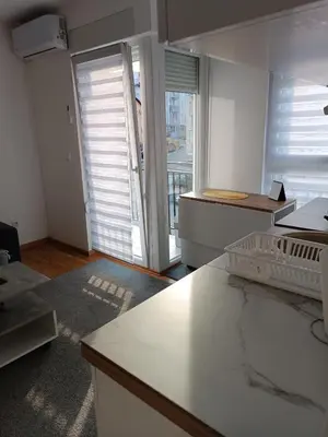 a kitchen with white counters and a large window at Lipa in Vrnjačka Banja
