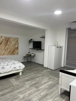 a bedroom with a bed and a kitchen with a refrigerator at Apartmani Stevanovic in Despotovac